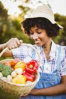 Smiling woman looking at basket of vegetables