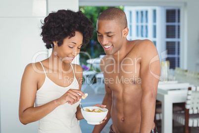 Happy couple eating breakfast in the kitchen