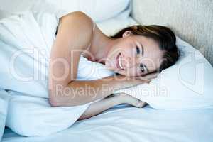 smiling woman lying in herr bed