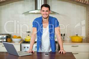 young man leaning on kitchen worktop