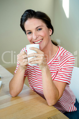 smiling woman sipping a cup of coffee