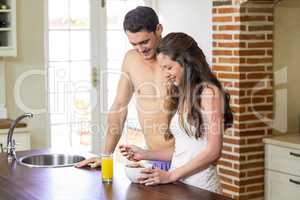 Young couple having breakfast in kitchen