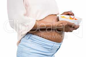 Pregnant woman holding fruit salad