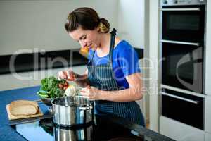 smiling woman cooking on the stove top