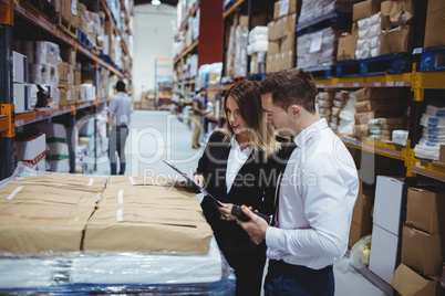 Warehouse managers looking at clipboard