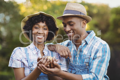 Smiling couple holding potatoes