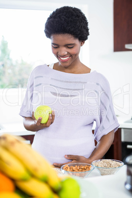 Pregnant woman holding apple