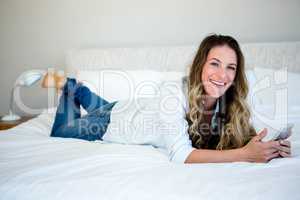 woman lying on her bed on her mobile phone