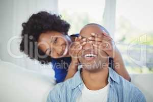 Happy woman covering her mans eyes