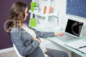 Pregnant woman using laptop