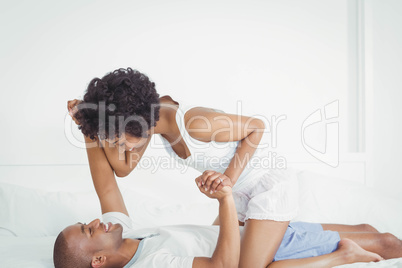 Happy couple playing on the bed