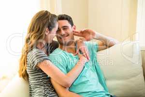 Happy young couple embracing on sofa