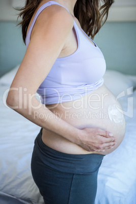 Pregnant woman with cream on her belly