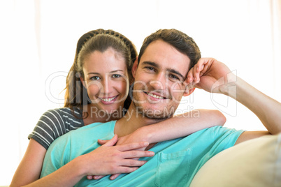 Portrait of young couple smiling on sofa