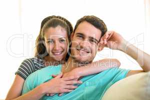 Portrait of young couple smiling on sofa