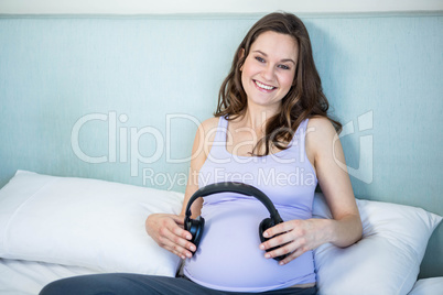 Pregnant making her bump listen to music with headphones