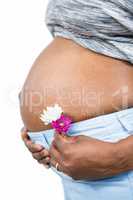 Pregnant woman with flower touching her belly