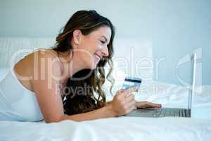 woman on her computer holding her credit card