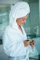 woman wearing a dressing gown holding face powder