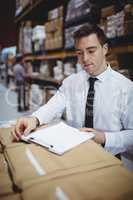 Warehouse manager looking at clipboard