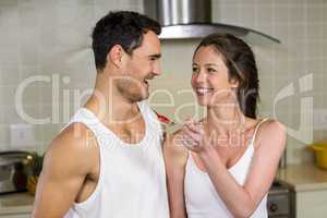 Young woman feeding breakfast to her man