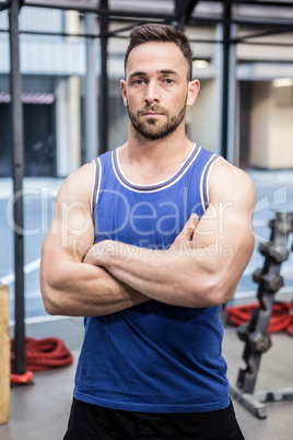 Muscular man standing with arms crossed