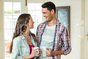 Happy couple standing with cup of tea