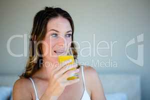 smiling woman drinking a glass of orange juice