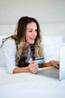 woman on her laptop holding her credit card
