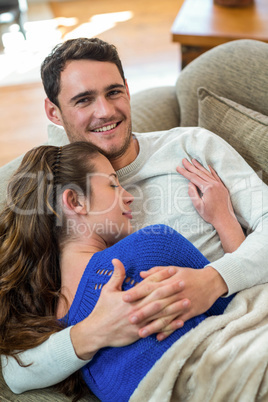 Young couple cuddling on sofa