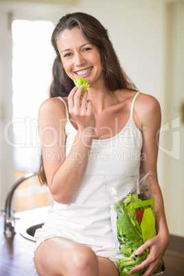 Happy young woman holding vegetable