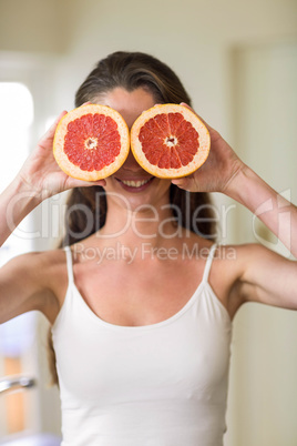 Young woman holding slices of blood orange