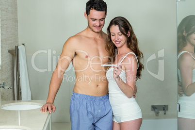 Happy couple looking at pregnancy test kit
