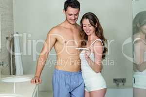 Happy couple looking at pregnancy test kit