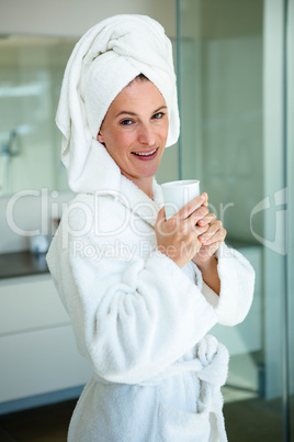 woman in a dressing gown drinking a cup of coffee