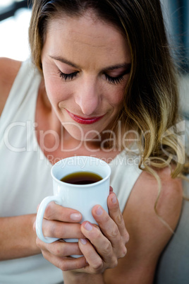 smiling woman sipping a cup of coffee