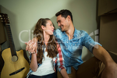 Young couple sitting together on the floor and smiling