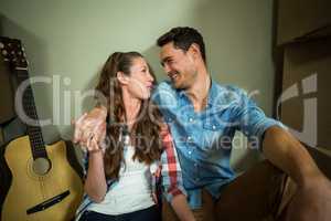 Young couple sitting together on the floor and smiling