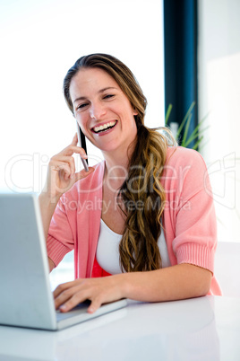 smiling woman on her laptop and mobile phone