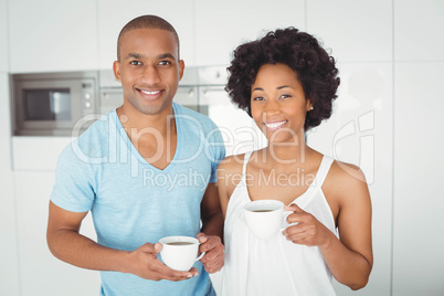 Portrait of smiling couple holding mugs