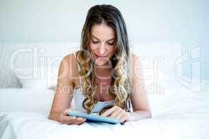 smiling woman typing on her tablet