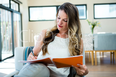 womasmiling woman writing in a notebook