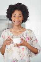 Portrait of smiling woman holding white cup