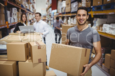 Smiling man carrying box