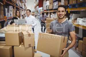 Smiling man carrying box