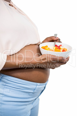 Pregnant woman holding fruit salad