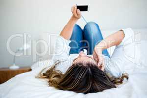 woman lying on her bed listening to music