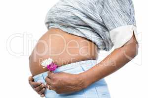 Pregnant woman with flower touching her belly