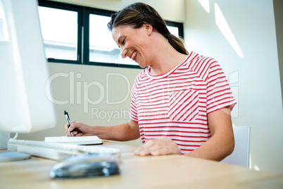 smiling business woman writing in a notepad