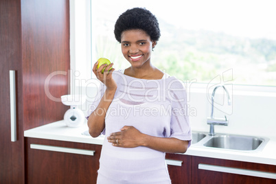 Pregnant woman holding apple